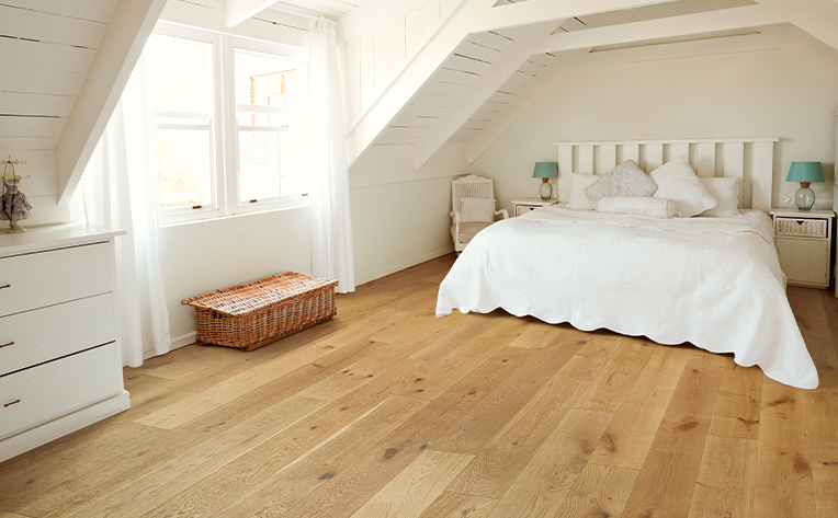 hardwood floors with white bed and window